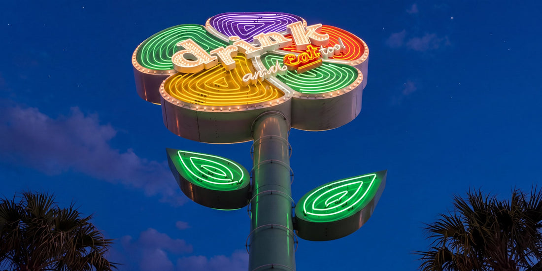 The Drink and Eat Too flower sign lit in neon at dusk on Harmon Avenue in Las Vegas